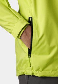 Chaqueta amarillo neón brillante con un diseño elegante; cuenta con un bolsillo con cremallera y puños elásticos; material sintético suave.