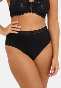 Black lace bralette with a scalloped edge and structured cups, paired with high-waisted black briefs featuring a lace-accented waistband.