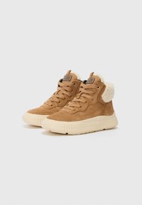 Zapatillas altas de ante marrón con un cuello de piel sintética crema, puntera redonda y suela de goma texturizada beige. Cuenta con cordones en la parte delantera y etiqueta de la marca.