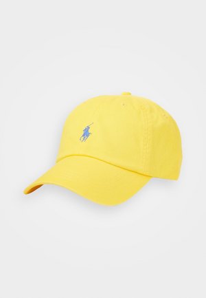 Żółta czapka z daszkiem z niebieskim haftowanym logo polo gracza na przodzie, prezentowana na białym tle.