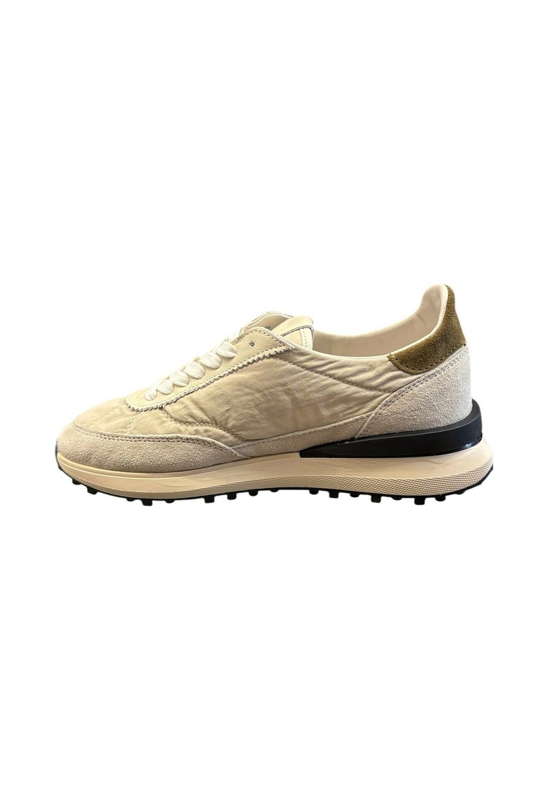 Sneaker beige con tomaia in tessuto strutturato, dettagli in camoscio, lacci tono su tono e suola in gomma nera a contrasto con piccoli tacchetti per la trazione.