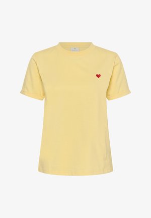 T-shirt jaune à manches courtes avec ourlets retroussés et un petit cœur rouge brodé sur la poitrine gauche.