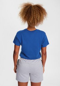 Blue cotton t-shirt with short sleeves, paired with light grey shorts. Simple design, solid colors, and casual fit.