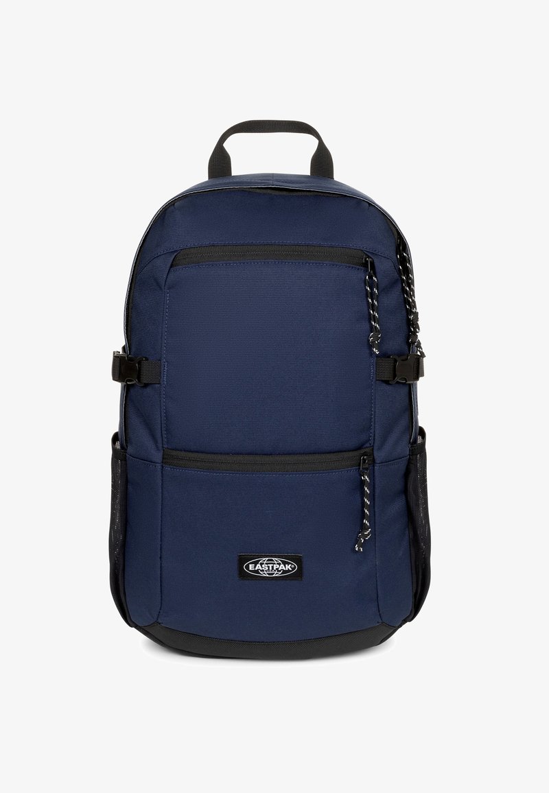 Mochila azul marino de tela resistente; cuenta con dos bolsillos frontales con cremallera, asa superior y correas ajustables. Fondo negro y bolsillo lateral de malla.