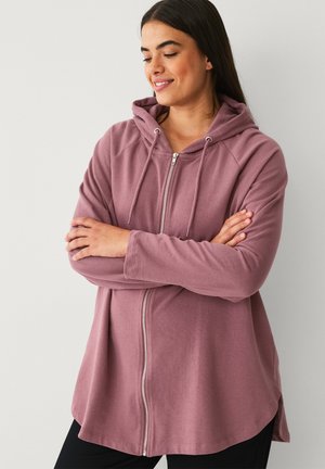 Lys mauve zip-up hoodie med rummelig pasform, raglanærmer og justerbar snøre ved hætten. Blødt stof med en glat tekstur.