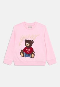 Felpa rosa con un orso ricamato che indossa una maglietta rossa e pantaloni corti blu, con la scritta "guess" in corsivo sulla parte anteriore.