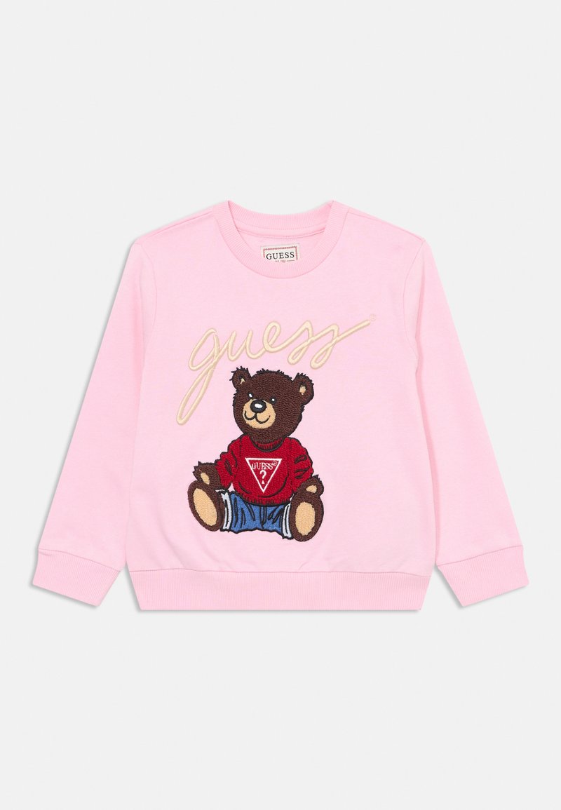 Sweatshirt rosa com um urso bordado a usar uma camisa vermelha e calções azuis, com "guess" em itálico na parte da frente.