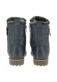 Une paire de bottes d'hiver en cuir bleu marine avec doublure en fourrure grise, zips latéraux et semelles en caoutchouc marron robustes, vues de l'arrière.