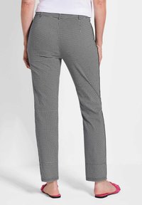 Schwarz-weiße karierte Hose mit geradem Bein, aus gewebtem Stoff. Sie hat eine glatte Textur und einen schlichten Saum.