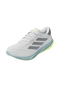 Zapatilla deportiva blanca con acentos grises y tres rayas oscuras. Presenta una parte superior texturizada y una suela de color teal con un acento amarillo. Diseño ligero.