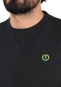 Dark gray sweatshirt with a crew neck and ribbed cuffs, featuring a small green logo on the left chest and textured fabric.