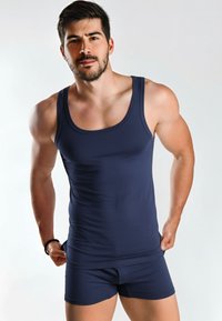 Canotta navy e pantaloni shorts coordinati realizzati in tessuto morbido, design aderente, con spalline larghe e scollatura alla regolare.