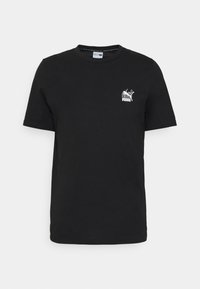 Černé krátkosrsté tričko Puma s malým bílým logem Puma obsahujícím pumu a stylizovaný design na levé straně hrudi.