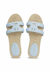 Ljusblå sandaler med en texturerad rep-sula. Två breda remmar har en stor logotyp. Slät fotbädd med varumärket präglat.