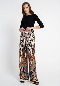 Spodnie o szerokich nogawkach z żywym abstrakcyjnym wzorem w odcieniach brązu, niebieskiego i kremowego. Wykonane z gładkiego materiału z elastycznym paskiem w talii.