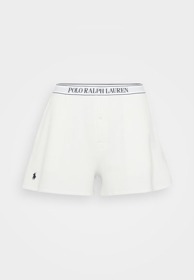 White waffle-knit shorts featuring a black and white branded waistband and a small embroidered logo on the left side.