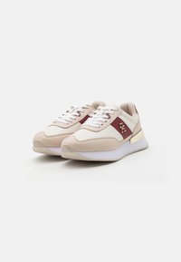Sneakers z beżową syntetyczną cholewką, bordowymi akcentami, białymi sznurowadłami i teksturowaną podeszwą. Złote wykończenia i subtelne detale brandingu.