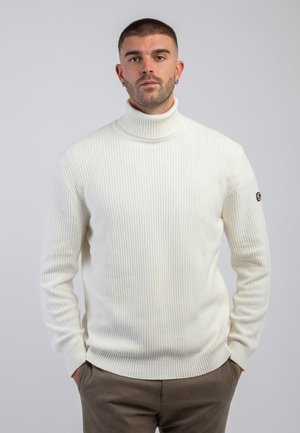 Maglione a collo alto bianco a coste con una forma aderente e tessuto testurizzato. Presenta un'etichetta con logo sulla manica sinistra.