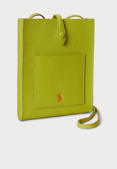 Zelena usnjena torbica z teksturirano obdelavo, sprednjim žepom in oranžnim logotipom. Ima dvojna zgornja ročaja in odstranljiv trak.