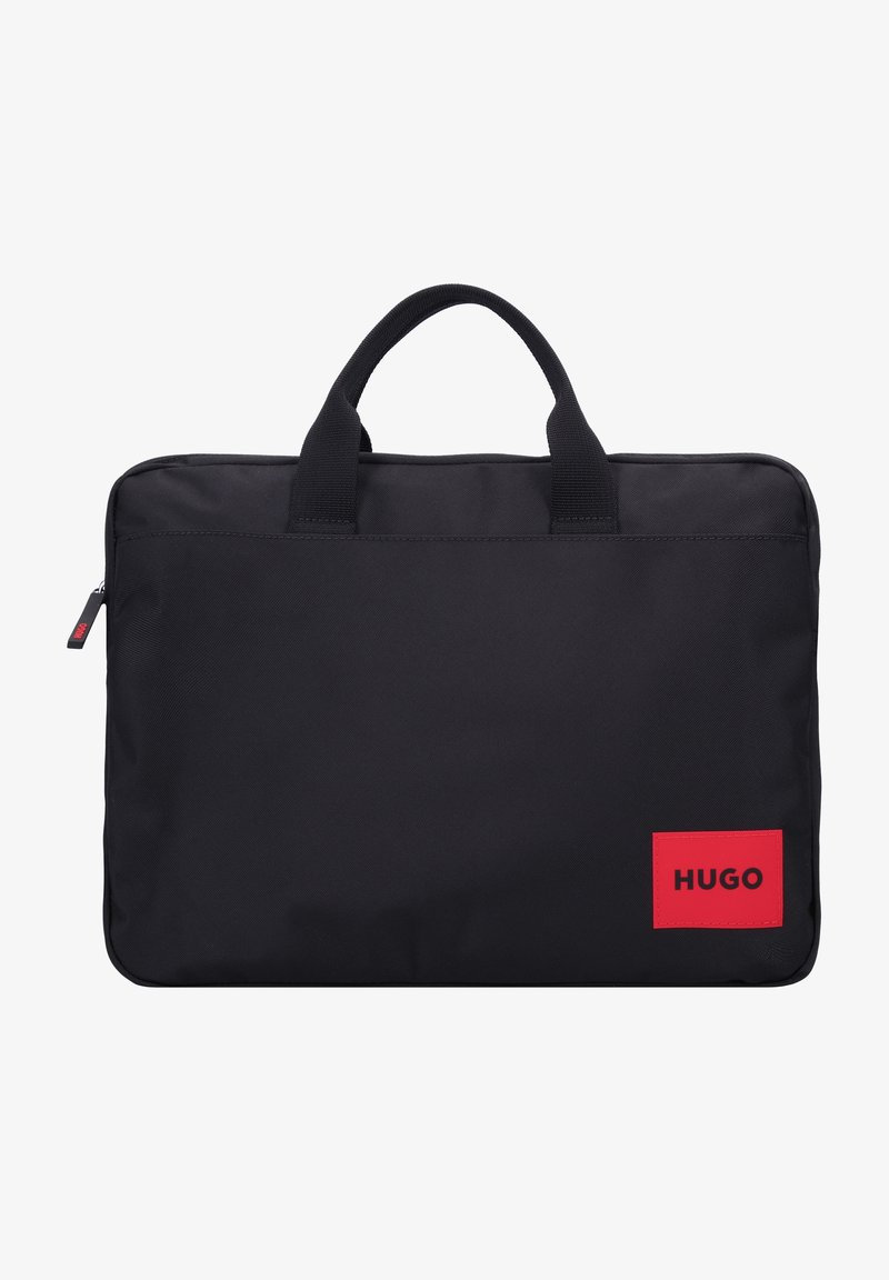 Sacoche d'ordinateur portable noire en tissu durable avec deux poignées. Dotée d'un patch rouge avec le logo "HUGO" en bas à droite. Design simple et rectangulaire.