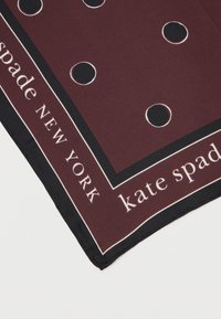 Βουργουνδικό μεταξωτό μαντήλι με λευκά κυκλικά μοτίβα, μαύρη τελείωση και κείμενο "kate spade NEW YORK" κατά μήκος της κάτω άκρης. Λείος προσανατολισμός.