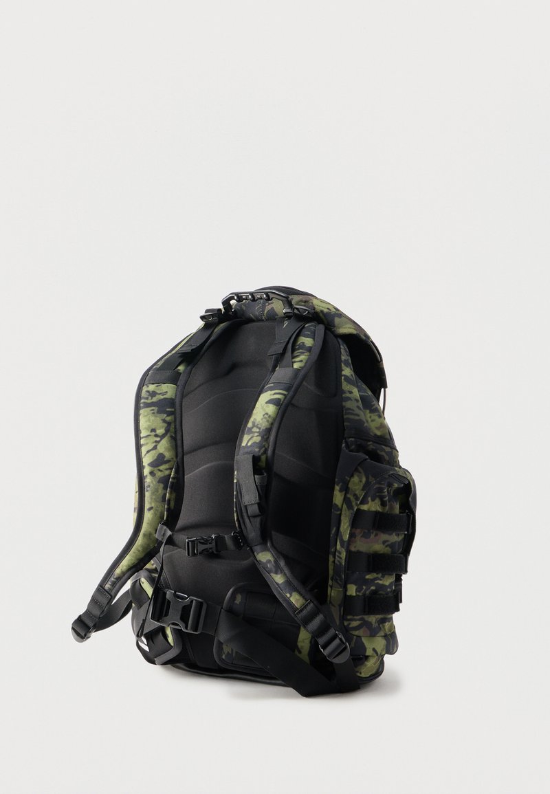 Rygsæk med camouflage-mønster, polstret ryg, justerbare skulderstropper, bryst- og taljespænder samt flere sidelommer.