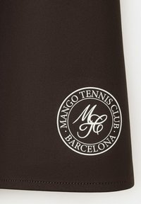 Tela negra con un logo circular blanco que dice "Mango Tennis Club Barcelona" y las iniciales estilizadas "MTC" en el centro.