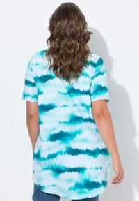 Camisa de tie-dye en tonos verde azulado y blanco, de manga corta y con un dobladillo redondeado, que presenta un corte holgado y una textura de tela suave.