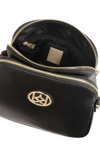 Borsa in pelle nera con zip dorata e logo circolare. L'interno foderato presenta una tasca con zip e un motivo a rilievo del marchio sul tessuto.