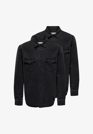 Kaksi mustaa, pitkähihainen farkkupaitaa, joissa on napit, kaulukset ja etutaskut läppineen, pinottuna valkoisen taustan päälle.