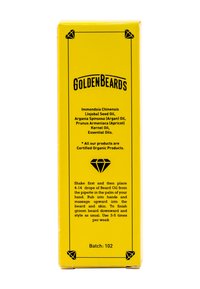 Gul rektangulär box märkt "Gyllene Skägg". Innehåller text om ingredienser och bruksanvisningar, med en diamantikon och batchnummer nederst.