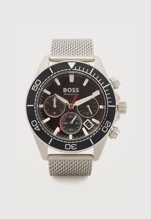 Silver BOSS wristwatch with black bezel, black dial, three subdials, date window, and mesh metal strap, showing time at 10:10:37.