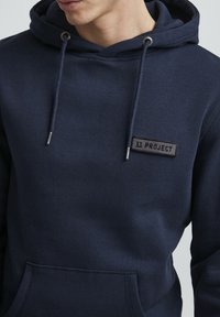 Felpa blu navy, in cotone, con cappuccio regolabile con cordino, tasca frontale, caratterizzata da un patch nero con il logo "11 PROJECT".