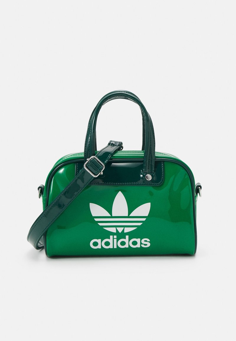 Sac à main en cuir synthétique vert, de forme arrondie, avec deux poignées supérieures, une bandoulière réglable et un grand logo Adidas blanc à l'avant.