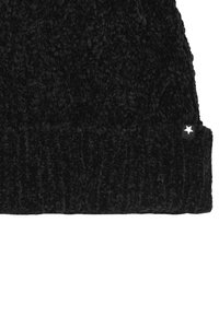 Crni pleteni beanie s mekim, teksturiranim završetkom i preklopljenim rubom. Ima mali bijeli akcent zvjezdice sa strane.