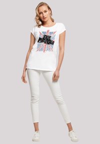 White cotton t-shirt featuring a colorful Union Jack design with "Sex Pistols" text in black, short sleeves, and relaxed fit.