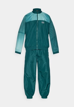 Teal tracksuit made of smooth, lightweight material. Jacket features a full zipper, ribbed collar, and gradient patterned sleeves. Pants are elasticized at the ankles.