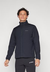 Schwarze isolierte Jacke mit hohem Kragen und Frontreißverschluss. Verfügt über elastische Bündchen und ein Salomon-Logo auf der Brust. Glatte Textur.
