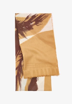 Jasnobrązowy, beżowy i ciemnobrązowy szalik w abstrakcyjny wzór o miękkiej fakturze i frędzlami na brzegach, złożony na białym tle.