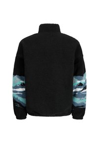 Schwarze Fleecejacke mit hohem Kragen, ausgestattet mit blauen und türkisfarbenen gemusterten Akzenten an den Ärmeln. Weicher, strukturierter Stoff in der gesamten Jacke.