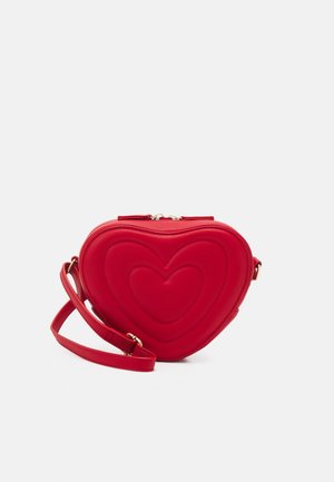 Sac bandoulière rouge en forme de cœur avec un motif cœur en couches et une sangle réglable sur fond blanc.