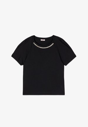 Camicia nera a maniche corte con scollo rotondo decorata da una fila di ornamenti rettangolari argentati lungo il colletto.