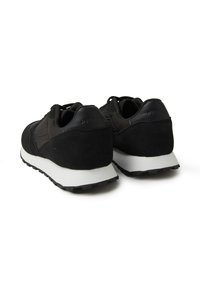 Scarpe sportive nere realizzate in suede e pelle, con una parte superiore testurizzata, suola bianca imbottita e suola nera con battistrada.