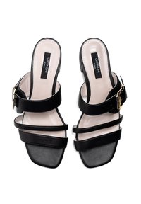 Schwarze Leder-Sandalen mit offenem Zehenbereich, die zwei Riemen mit einer goldenen Schnalle haben. Quadratförmiges Zehen-Design und gepolsterte Innensohle für Komfort.