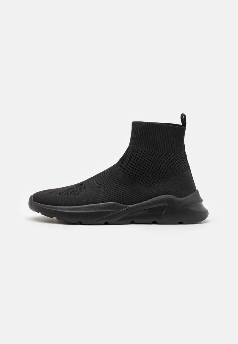 Black ankle-high sneaker with a textured knit body and elastic cuff. Features a smooth, padded sole for comfort and grip.