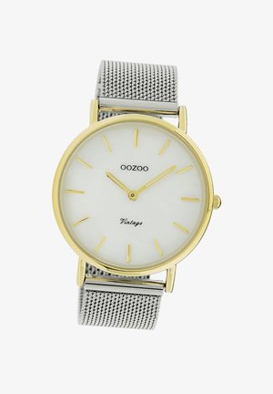 Montre avec accents dorés et un cadran rond blanc, index horaires dorés, et un bracelet en maille argentée. "OOZOO Vintage" est imprimé sur le cadran.