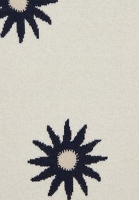 Textilie s krémovým pozadím, na které se nacházejí velké námořnické modré hvězdicové květy se béžovými kruhovými středisky a texturovanými detaily.