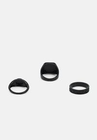 Conjunto de três anéis pretos: um plano, um com a parte superior arredondada, e um texturizado com padrões; todos apresentam um acabamento liso.