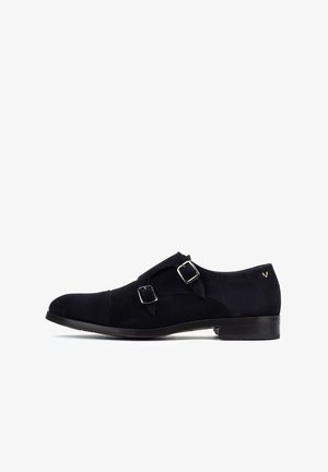 Zapato doble de monk strap de cuero de ante negro con hebillas en tono plateado, punta afilada y un acabado suave. Tacón bajo apilado.