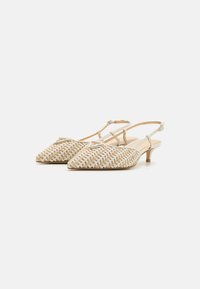 Décolleté intrecciati beige e bianchi con punta affilata e tacco basso. Presentano una sottile cinghia alla caviglia e dettagli decorativi in oro.